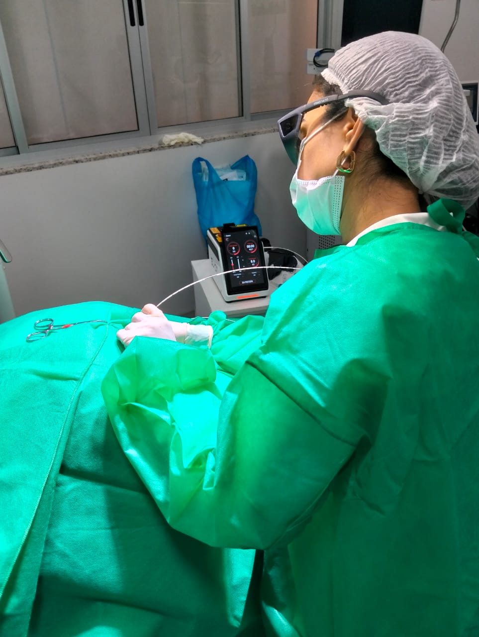 Dra. Vivian realizando procedimento a laser — equipamento com display de precisão